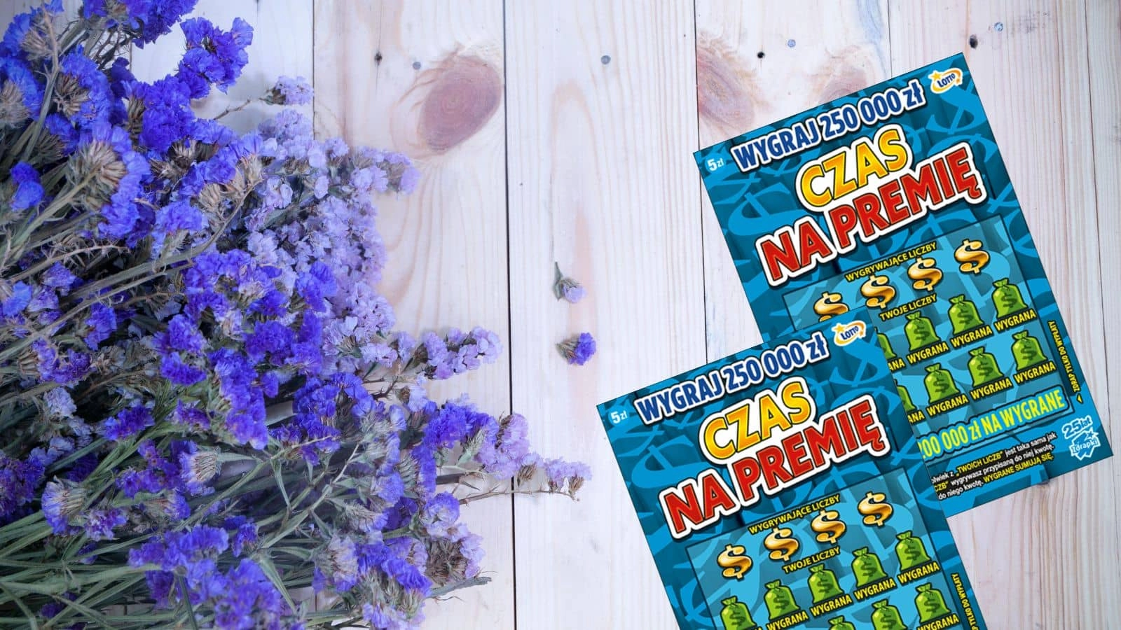 kwiaty oraz zdrapka lotto na drewnianej desce