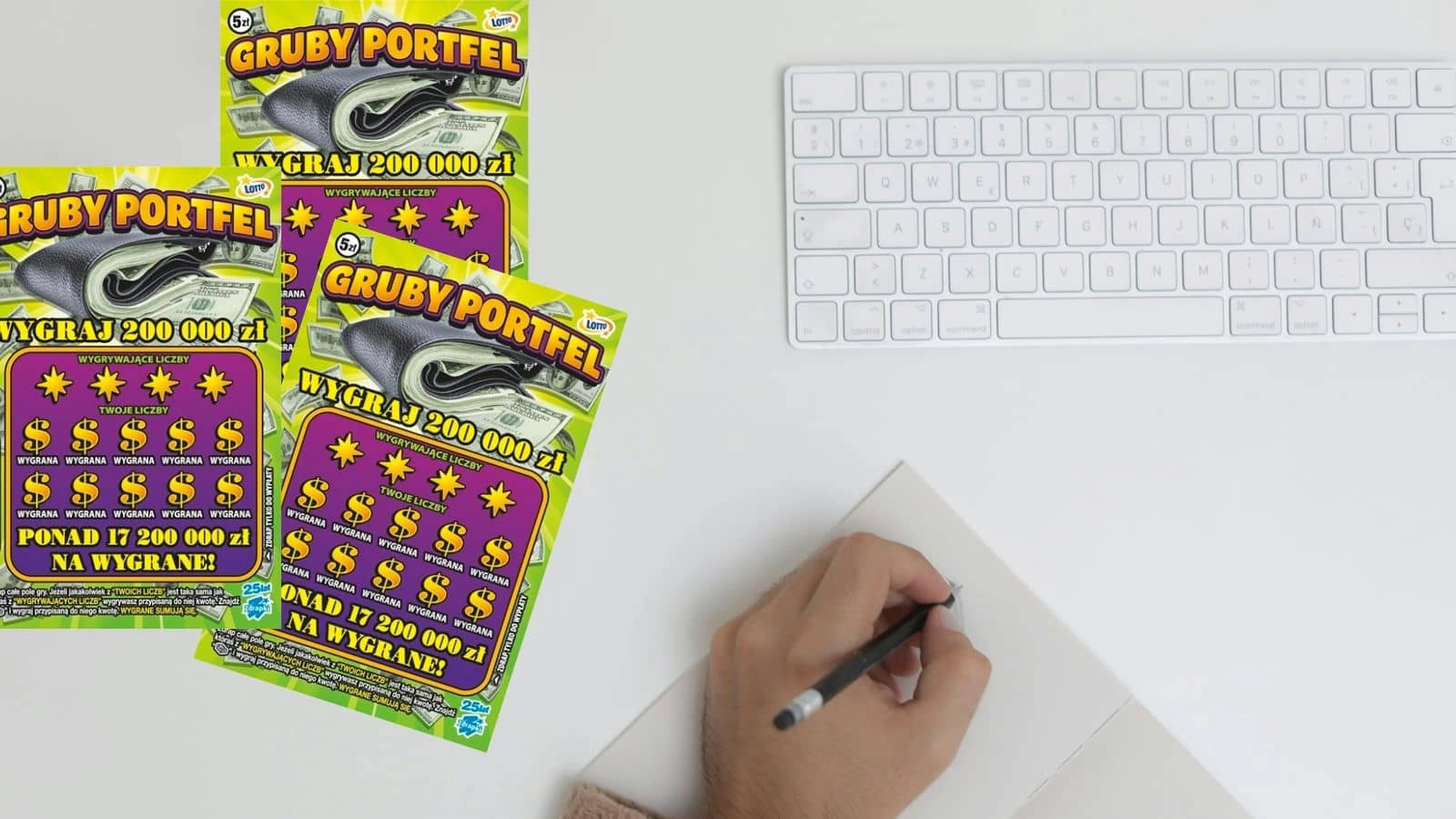 zdrapki lotto gruby portfel, płaska biała klawiatura, dłoń z ołówkiem, zeszyt na białym blacie stołu