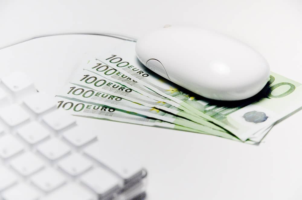 mysz komputerowa położona na banknotach 100 euro

