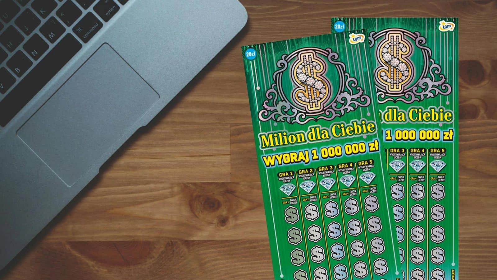 szaro srebrny notebook, zdrapki Lotto Milion dla Ciebie na jasnym drewnianym blacie stołu