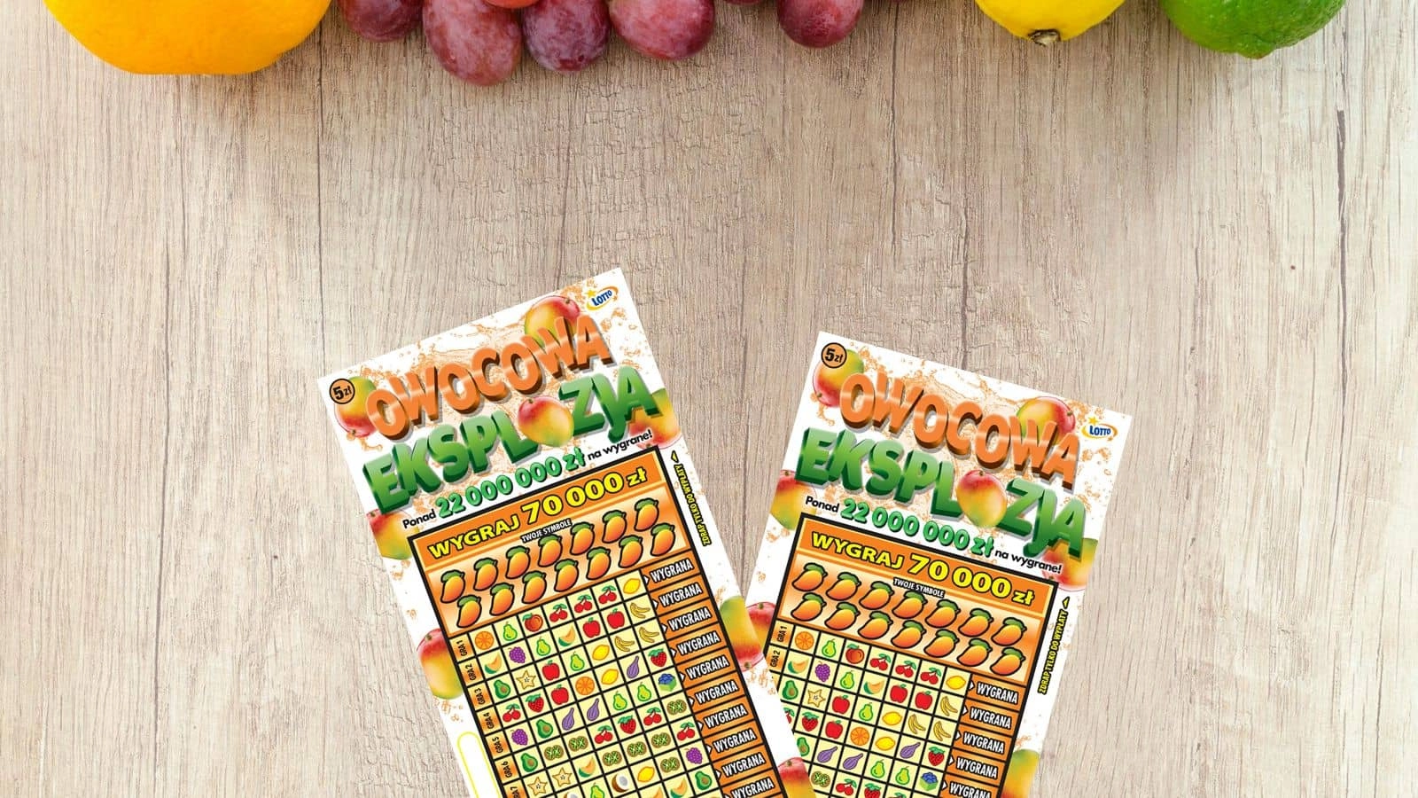 zdrapki lotto Owocowa Eksplozja na jasno drewnianym blacie stołu, różne owoce u góry