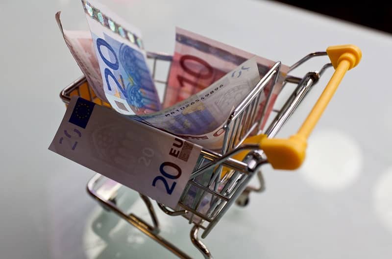 banknoty euro w miniaturowym wózku sklepowym