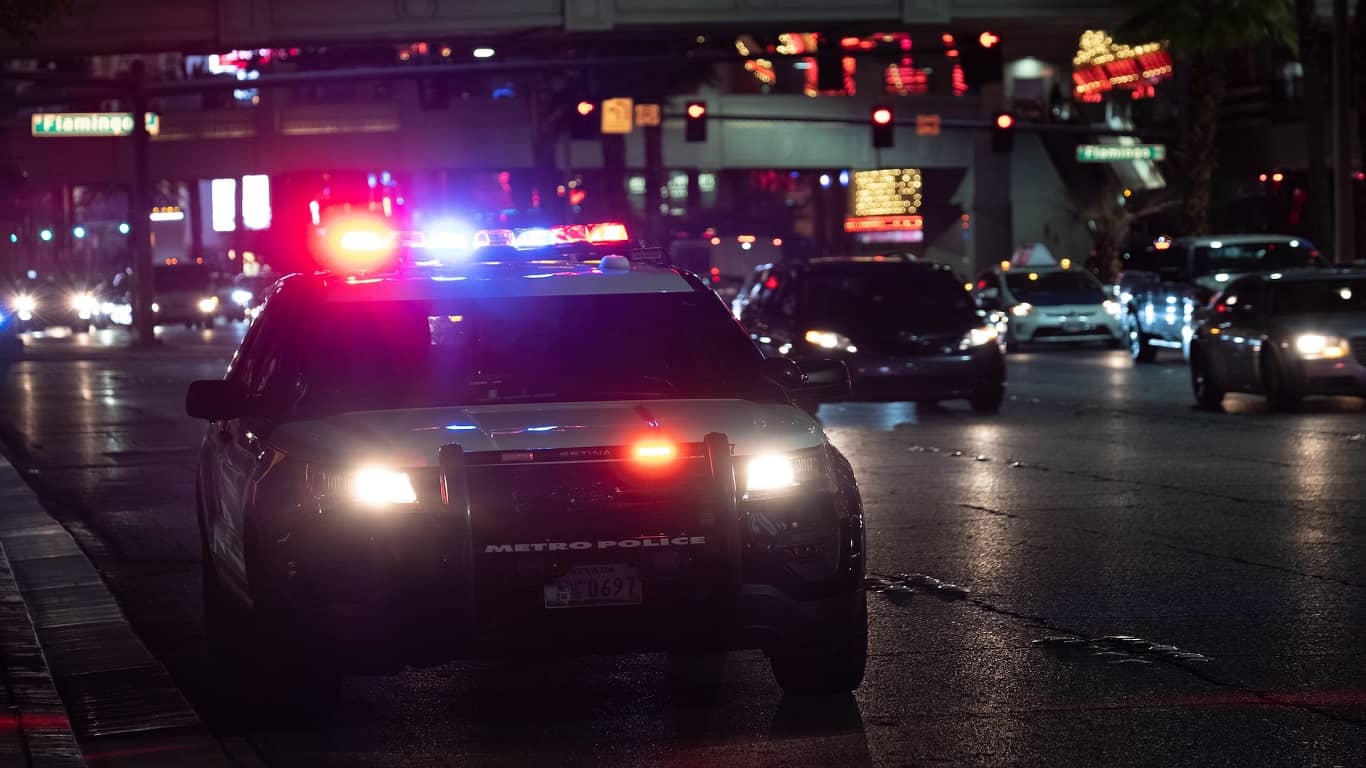 radiowóz policyjny stojący przy chodniku nocą