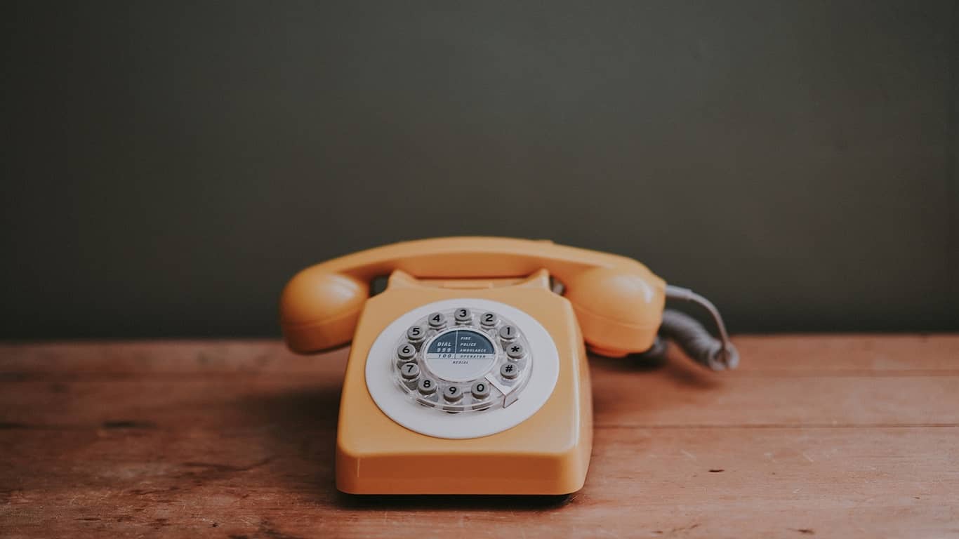 żółtawy stary telefon na drewnianym stole